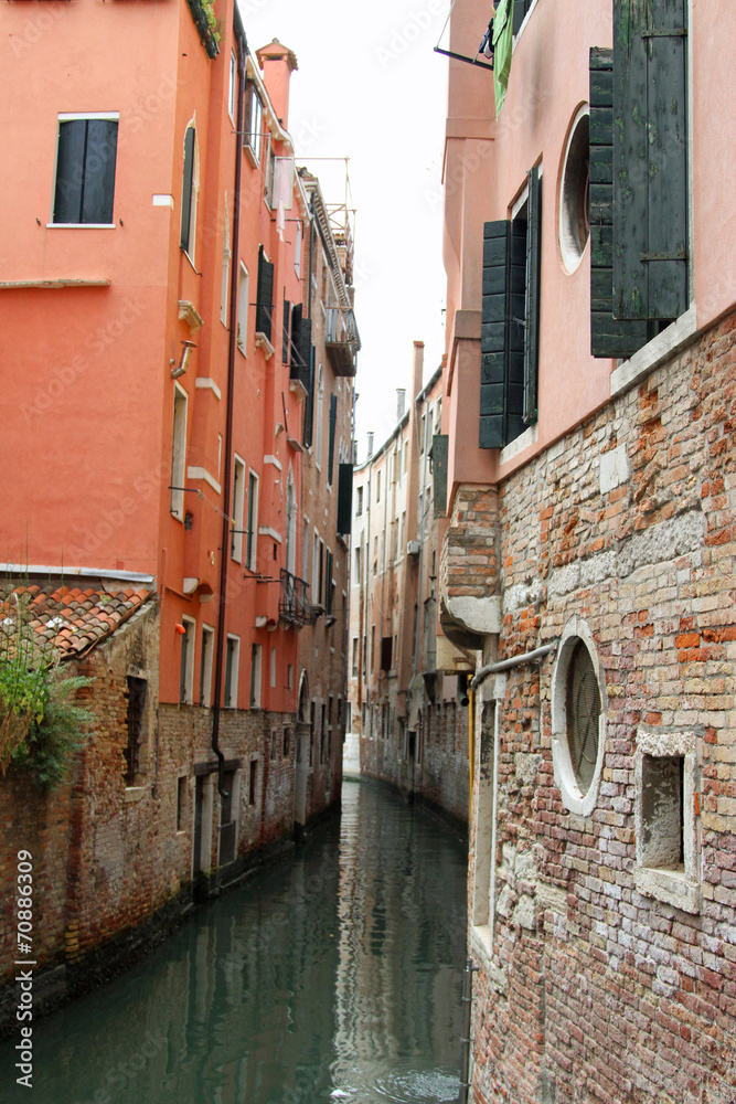 narrow navigable canal between the tall houses of Venice in Ital