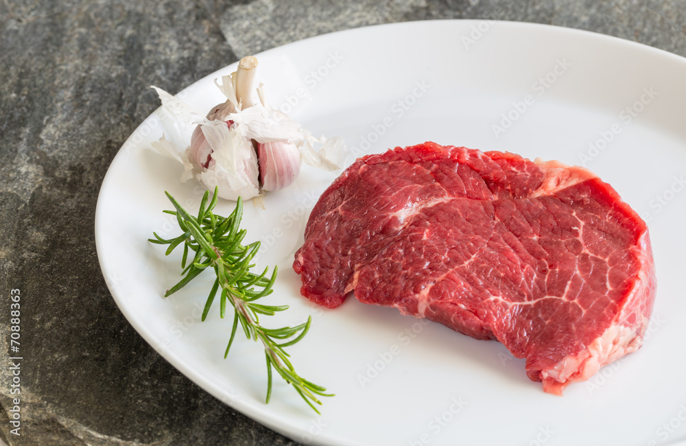 Rohes Rindersteak mit Rosmarin und Knoblauch Rohes Rindersteak mit Rosmarin und Knoblauch