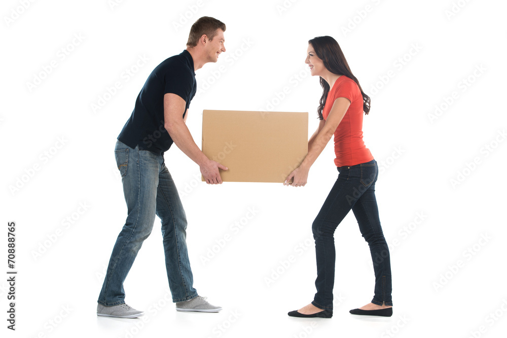 Beautiful young couple holding big heavy box. Beautiful young couple holding big heavy box.