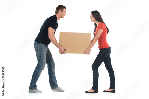 Beautiful young couple holding big heavy box.