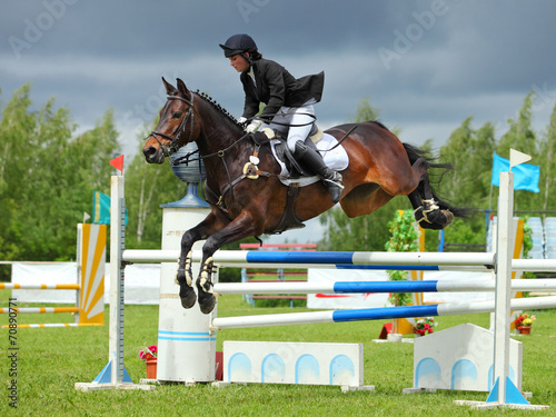 Obraz na płótnie Rider on bay horse in sports jumping show w salonie