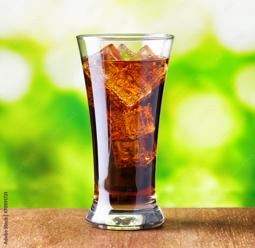 Glass of cola with ice on nature background Glass of cola with ice on nature background