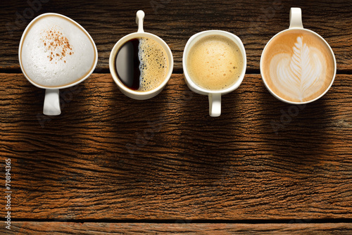 Variety of cups of coffee on old wooden table