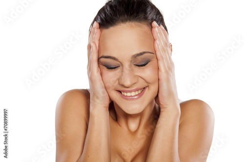 ashamed and smiling woman holding her face with her hands