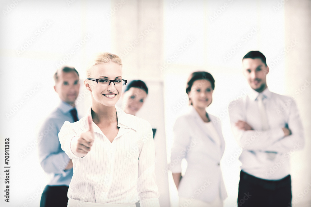 businesswoman in office showign thumbs up businesswoman in office showign thumbs up