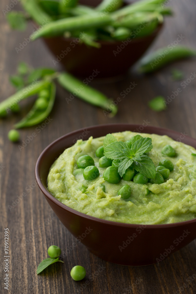 Mashed green peas and potatoes in a bowl on a wooden table Mashed green peas and potatoes in a bowl on a wooden table