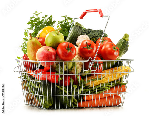 Wire shopping basket with groceries isolated on white