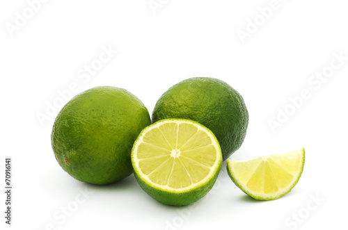 Limes with slices and leaves isolated on white background
