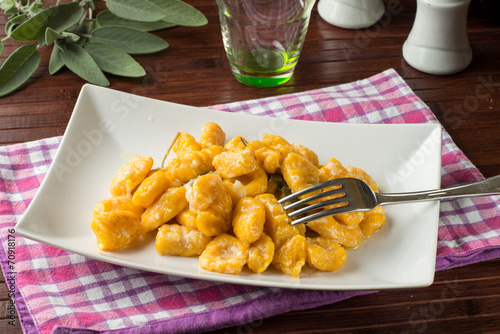 Gnocchi di zucca conditi nel piatto photo