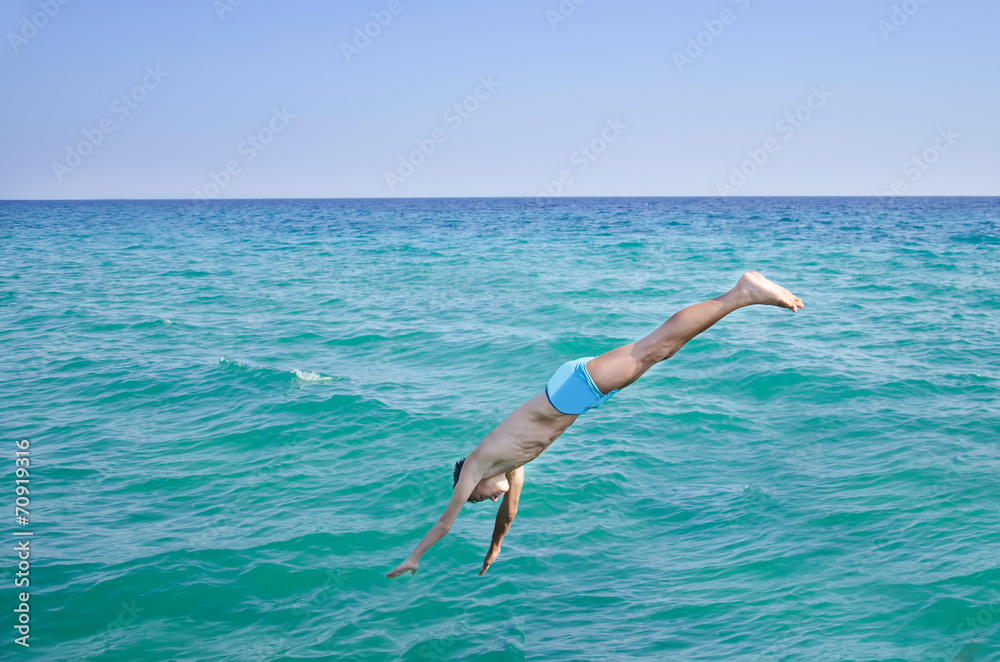 Side view of a boy jump diving