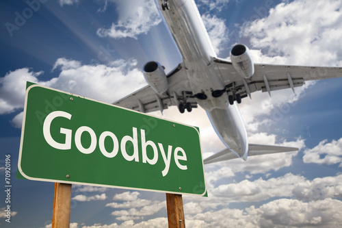 Goodbye Green Road Sign and Airplane Above