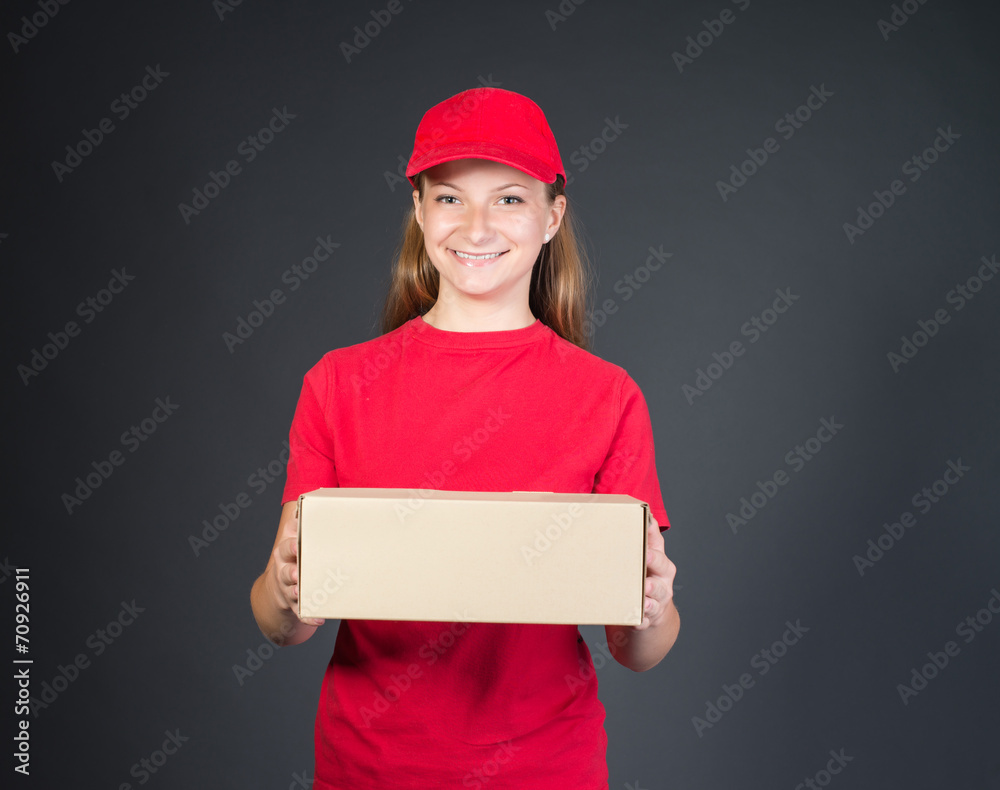 Delivery person delivering package smiling in red uniform. Delivery person delivering package smiling in red uniform.
