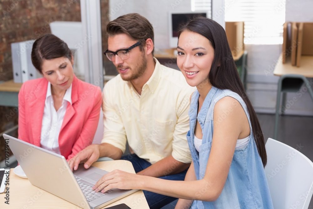 Business team working together with one smiling at camera