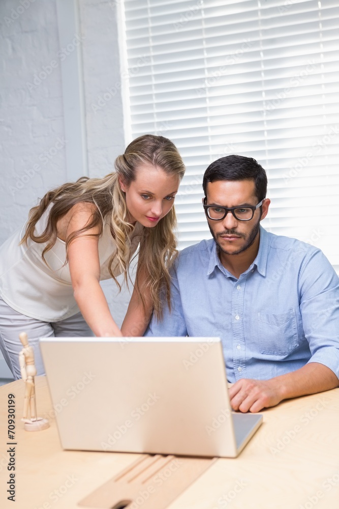 Casual colleagues using laptop at office Casual colleagues using laptop at office
