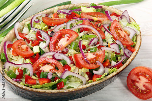 Fresh salad with tomato on wooden background