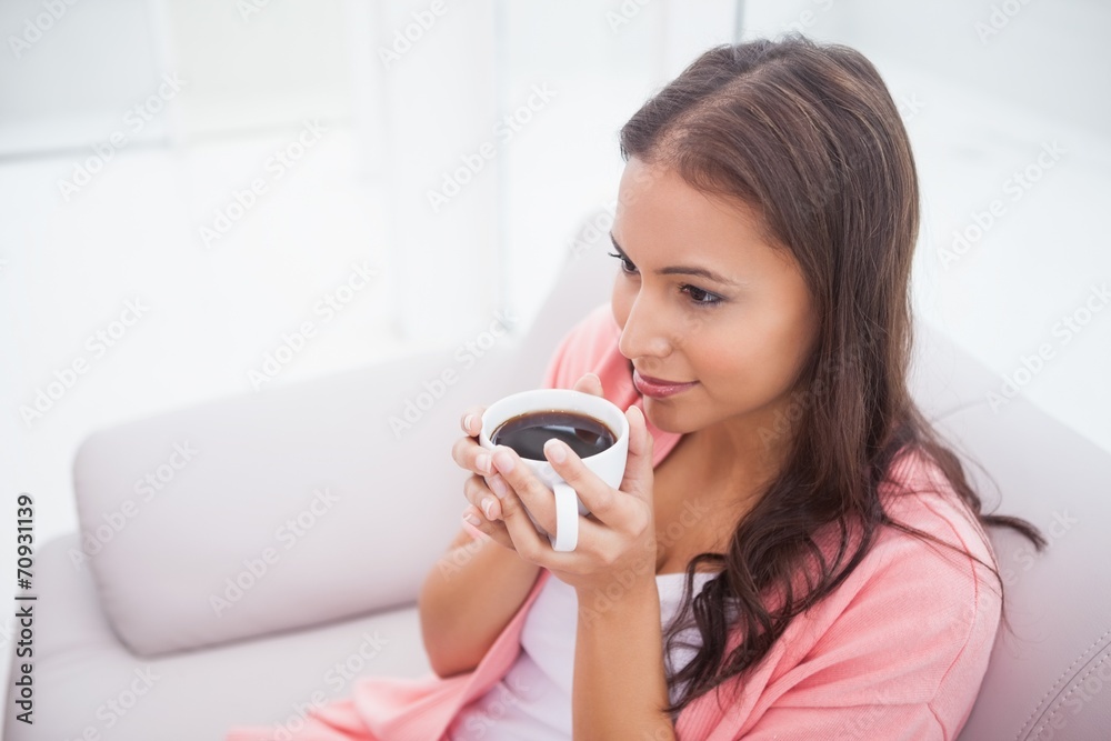 Pretty brunette enjoying coffee on the couch Pretty brunette enjoying coffee on the couch