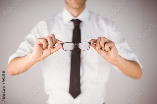 Businessman holding his reading glasses