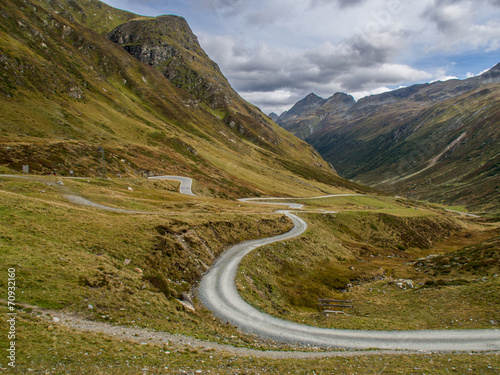 geschwungene Schotterstrasse in den Bergen