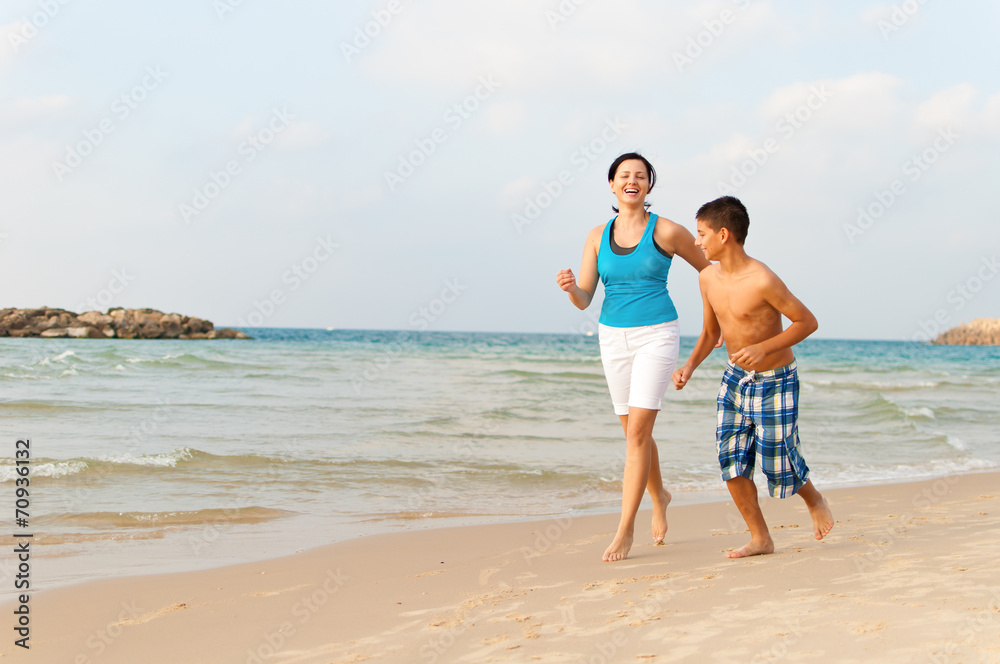 Mother with her son are running on the beach and having fun Mother with her son are running on the beach and having fun
