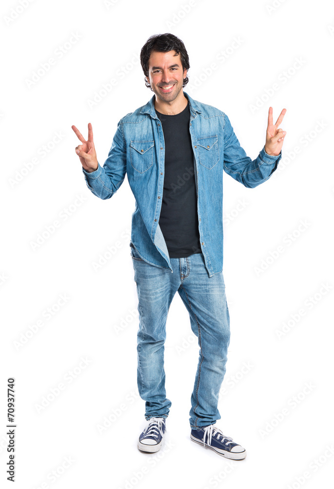 Man doing victory gesture over white background Man doing victory gesture over white background