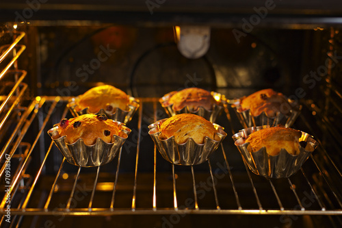 Baking cupcakes with raisins in baskets are baked in the oven