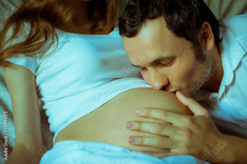 Image of happy future dad kiss the belly of his pregnant wife