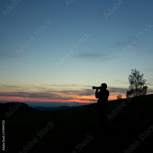 silhouetted photographer in sunset sky