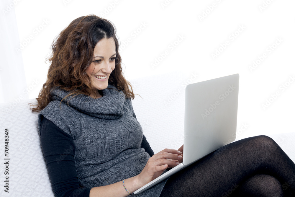 Naklejka premium woman with laptop on white sheet in her bed at home