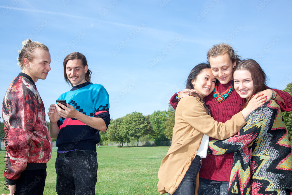 Men stand next group of women hugging each other