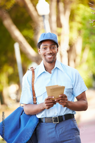 Mailman Walking Along Street Delivering Letters