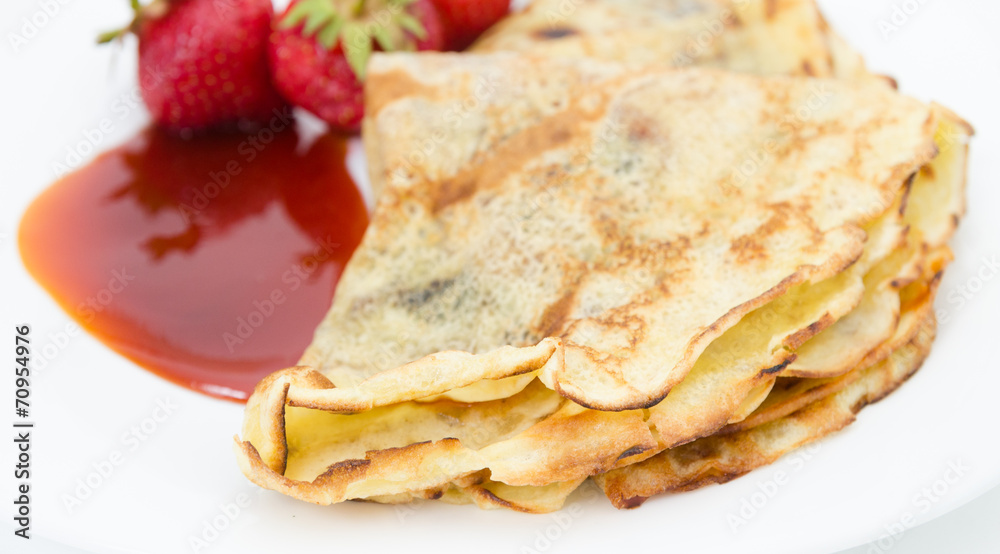 Close view of pancake crust with strawberries and jam on white Close view of pancake crust with strawberries and jam on white