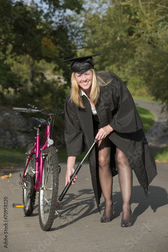 Cap and gown university student pumping tyre