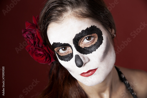 Woman with makeup of la Santa Muerte with red roses