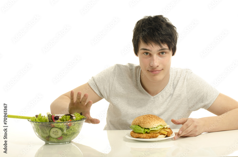 Man holding in front a bowl of salad and a big hamburger