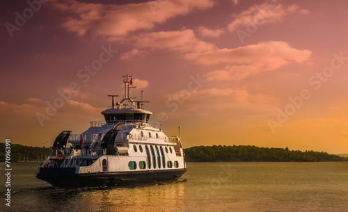 Fotografie, Tablou Small ferry cruising in Oslo fjord at sunset, Oslo, Norway