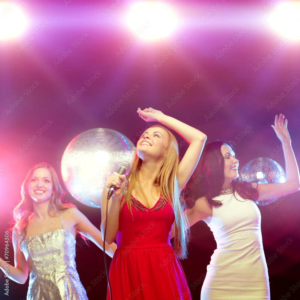 three smiling women dancing and singing karaoke three smiling women dancing and singing karaoke