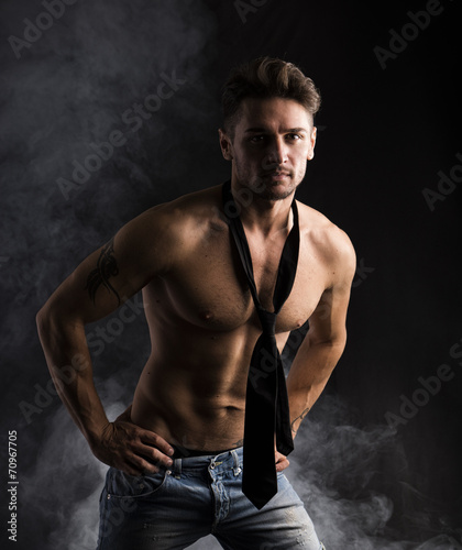 Handsome shirtless muscular man standing on dark background © theartofphoto