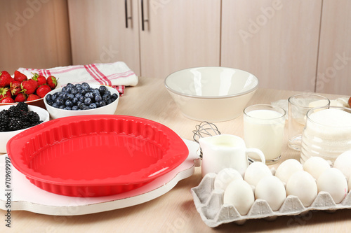 Baking tasty pie and ingredients for it on table in kitchen