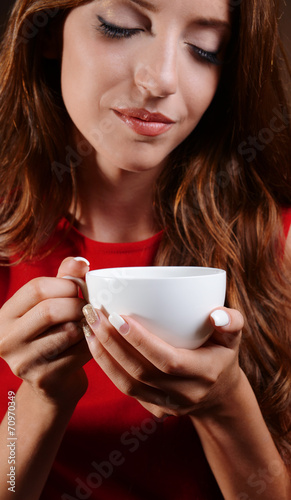 Beautiful young girl with cup of coffee close-up