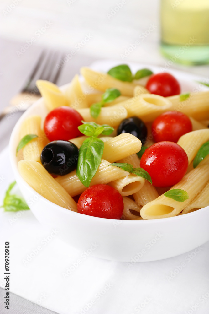 Pasta with tomatoes, olives and basil leaves in bowl Pasta with tomatoes, olives and basil leaves in bowl