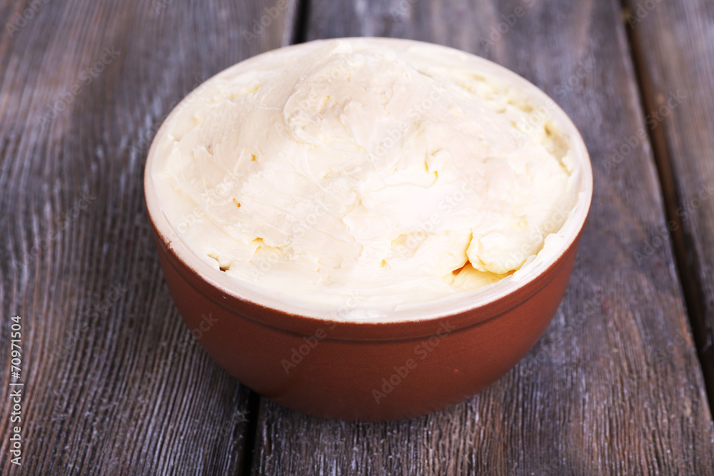 Fresh homemade butter in bowl, on color wooden background Fresh homemade butter in bowl, on color wooden background
