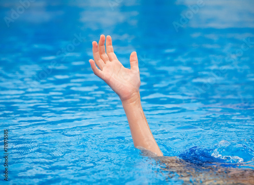 A hand of a drowning person stretching out of the water 