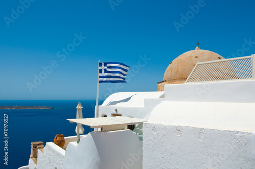 Oia Orthodox church and Greek flag.Thira  Santorini   Greece.