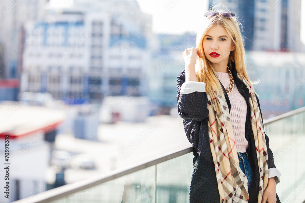 Stylish fashion portrait of blonde woman. Posing in the city