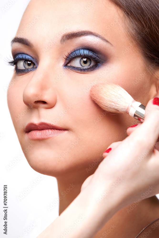 Detail of the face of a girl with a brush for makeup