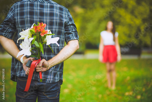 Man ready to give flowers to girlfriend