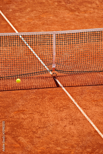 Tennis net detail with ball in the air