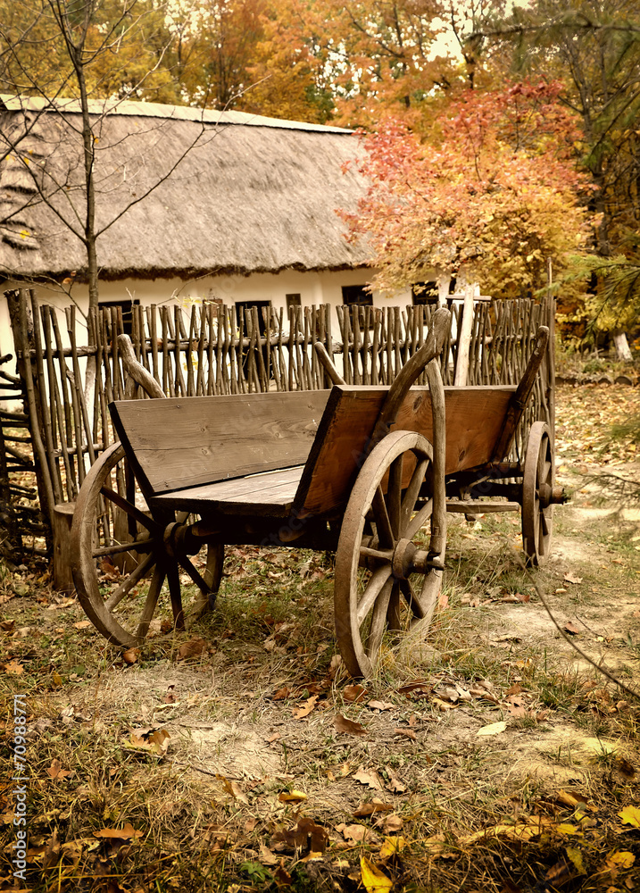 Vintage wooden cart in the yard in the autumn