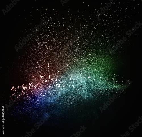 Colourful powder exploding isolated on black