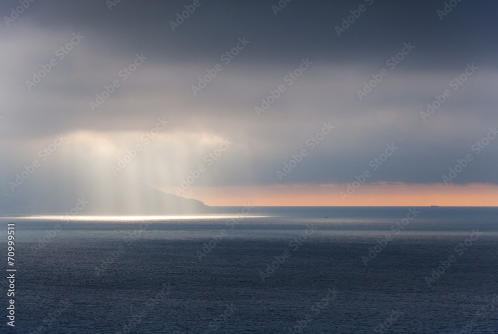 Bright sunlight goes through stormy clouds. Tangier bay, Morocco